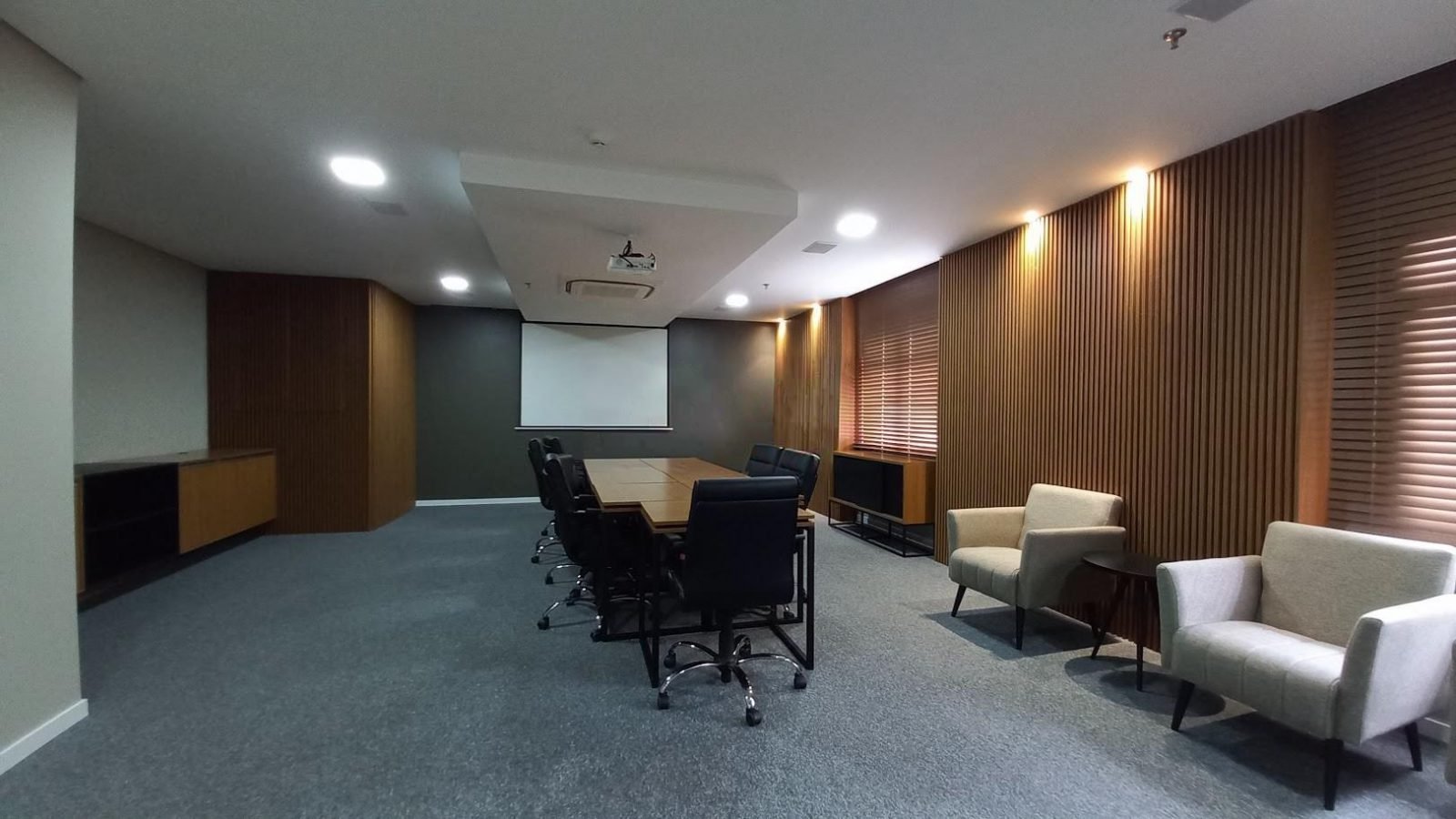Sala de reunião com mesa ampla e projetor