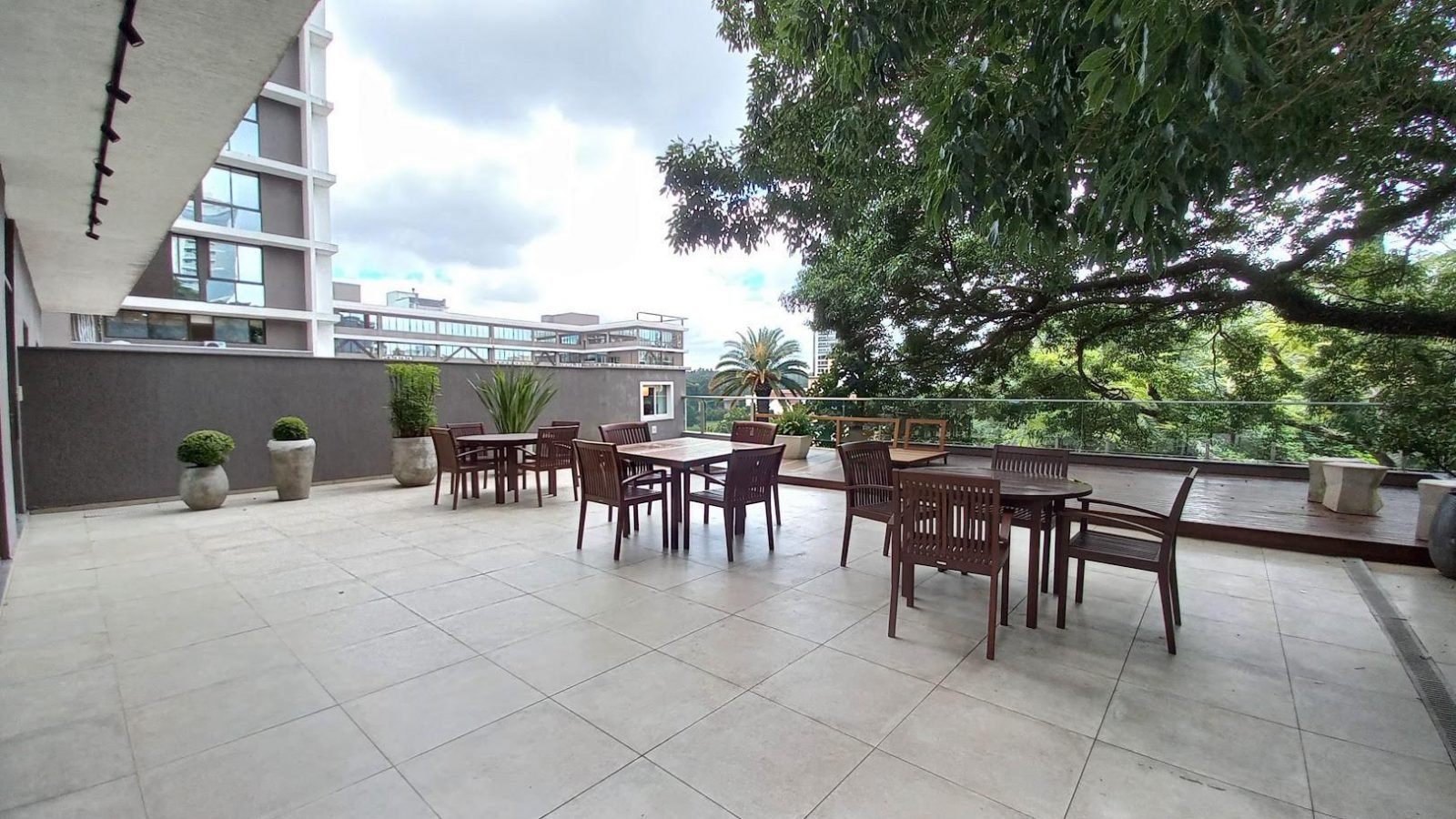 Terraço com mesas ao ar livre e árvores